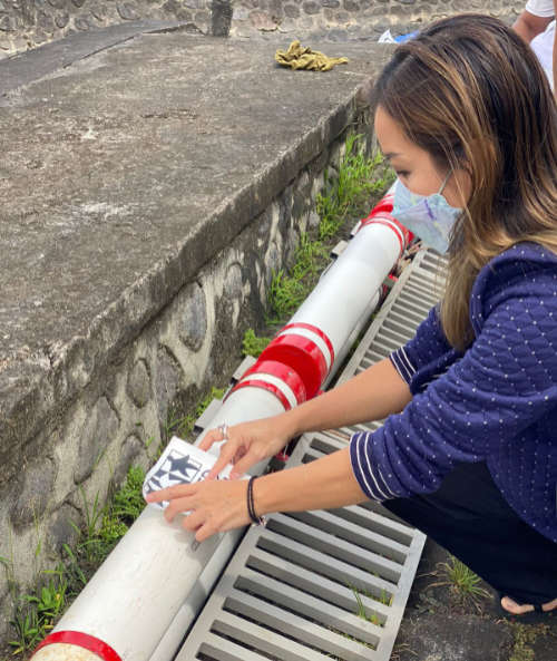 Shared Earth Director Yuli Sjahlendra applies our logo to the barrier